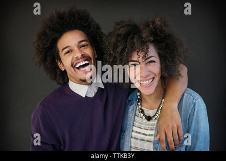 Portrait of happy businessman standing bras autour de collègue sur fond noir Banque D'Images