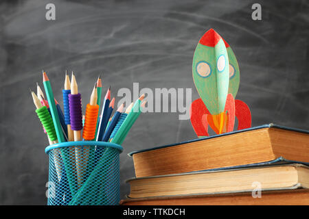 Retour à l'école. concept de fusée en carton et des crayons plus de livres en face de classe tableau noir Banque D'Images