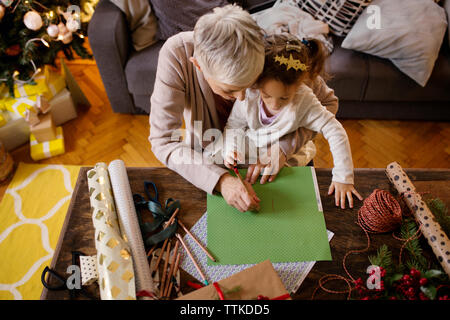 Vue de dessus de la grand-mère et petite-fille dessin sur le papier à la maison Banque D'Images