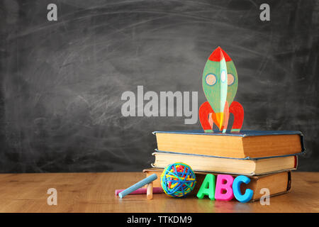 Retour à l'école. concept de fusée en carton et des crayons plus de livres en face de classe tableau noir Banque D'Images