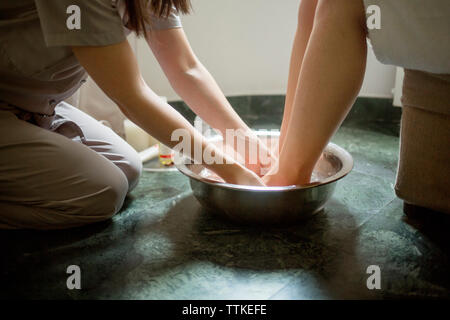 Au milieu du thérapeute donnant massage des pieds pour femme à spa Banque D'Images