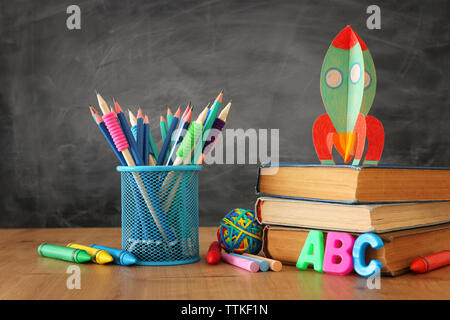 Retour à l'école. concept de fusée en carton et des crayons plus de livres en face de classe tableau noir Banque D'Images