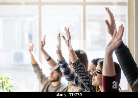 Sensibilisation des élèves pendant la leçon en classe les mains Banque D'Images