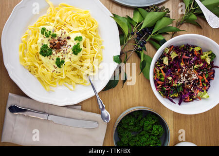 Vue de dessus de la salade avec des pâtes spaghetti servi sur table Banque D'Images