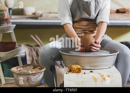 Portrait de femme en argile moulage potter alors qu'il était assis dans l'atelier Banque D'Images