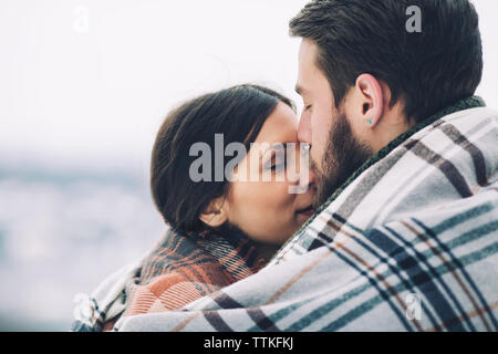 Close-up of romantic couple enveloppé dans l'écharpe Banque D'Images