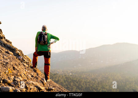 Man Randonnées montagne lors d'une journée ensoleillée Banque D'Images