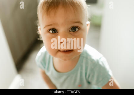 Baby Girl standing in doorway smiling légèrement vers le haut Banque D'Images