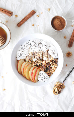 Portrait de tranches de pommes et le yogourt dans les céréales pour petit-déjeuner sur la table Banque D'Images