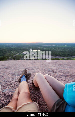 La section basse du couple lying on mountain pendant le coucher du soleil Banque D'Images