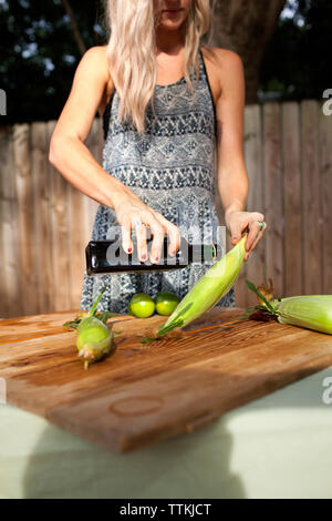 Portrait woman pouring olive oil sur le maïs Banque D'Images