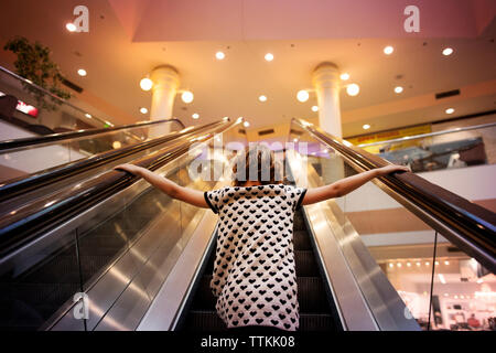 Low angle view of Girl standing on escalator Banque D'Images