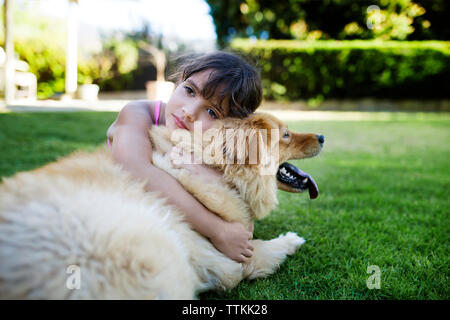 Girl resting with dog in yard Banque D'Images