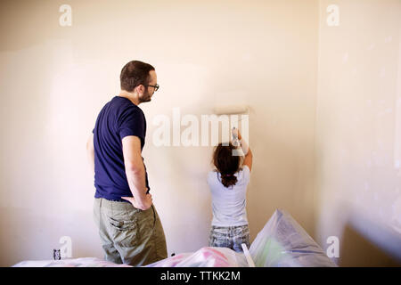 L'homme à la fille au mur peinture en chambre Banque D'Images