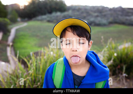 Close-up of boy sticking out tongue sur terrain Banque D'Images