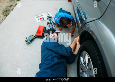 Portrait de l'enseignement du père fils pour réparer voiture au garage Banque D'Images