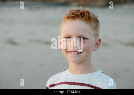 Portrait of smiling boy with freckles at beach Banque D'Images