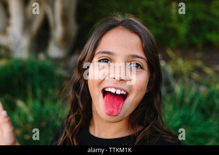 Close-up portrait of girl sticking out tongue at park Banque D'Images