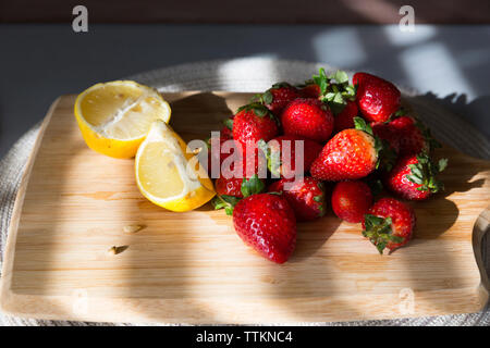 Close-up de fraises et de citrons en tranches sur une planche à découper Banque D'Images