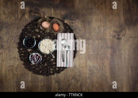 Vue de dessus de la céréale de petit déjeuner avec des fruits et des œufs sur la plaque mat sur table en bois Banque D'Images