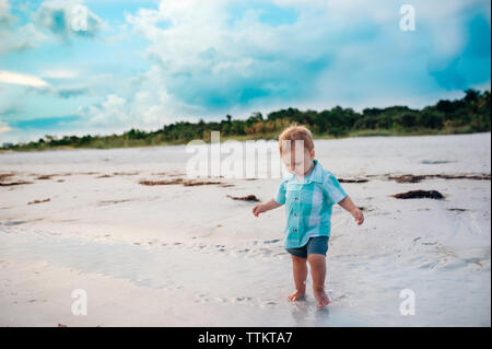 Bébé garçon walking on Beach en Floride avec chemise bleue sur Banque D'Images