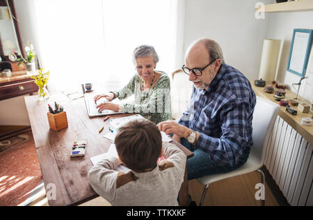 Heureux grands-parents d'aider à l'élaboration à la maison garçon Banque D'Images