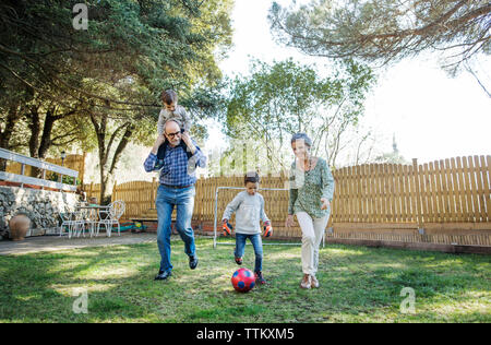 Toute la longueur de leurs grands-parents et petits-fils joue au soccer at yard