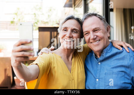 Cheerful young couple par selfies smart phone at porche Banque D'Images