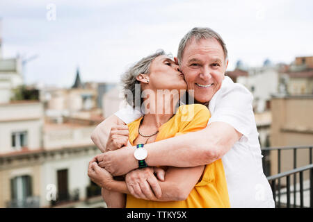 Mature romantique woman kissing man on terrace Banque D'Images