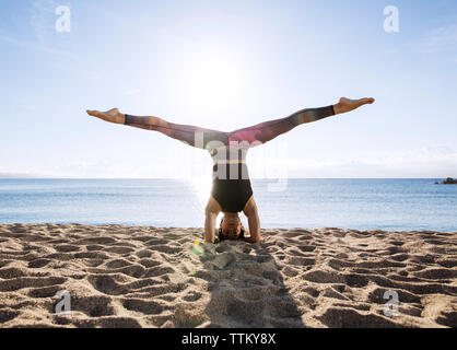 Jeune femme avec des jambes effectuant wavecrest on beach Banque D'Images