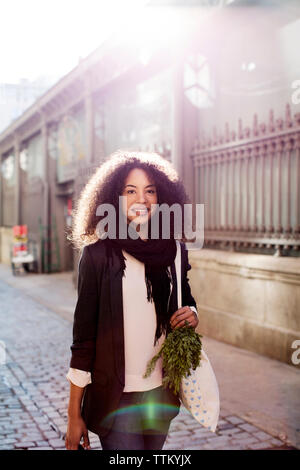 Portrait of smiling woman standing on city street Banque D'Images