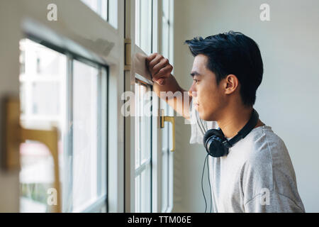 Thoughtful woman fenêtre tout en standing in office Banque D'Images