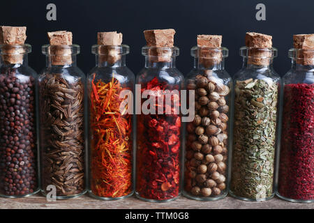 Différentes épices dans de petites bouteilles en verre, close-up Banque D'Images