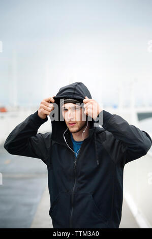 Portrait of smiling woman wearing Hooded Jacket athlète masculin sur Bay Bridge Banque D'Images