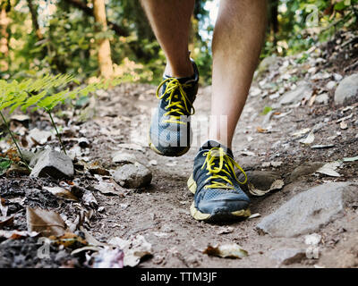 La section basse de l'homme marche sur le sentier de terre Banque D'Images