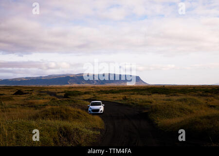 Blanc Compact voiture garée sur les dunes de sable noir en Islande Banque D'Images