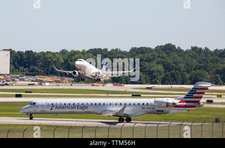Un avion commercial de United Airlines décolle de l'aéroport international Charlotte-Douglas alors qu'un Américain Eagle jet attend son tour. Banque D'Images