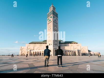 Vue arrière du friends standing contre Mosquée Hassan II Banque D'Images