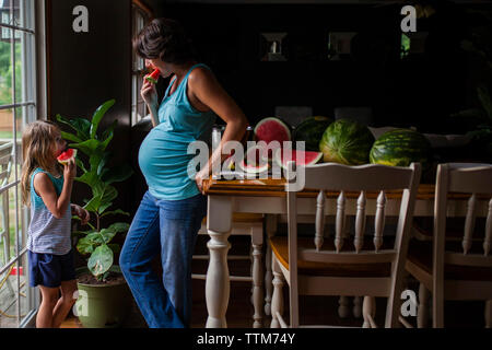 Mother and Daughter eating watermelon at home Banque D'Images