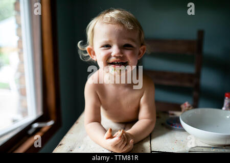 Girl Laughing with messy face après sweet treat colorés Banque D'Images