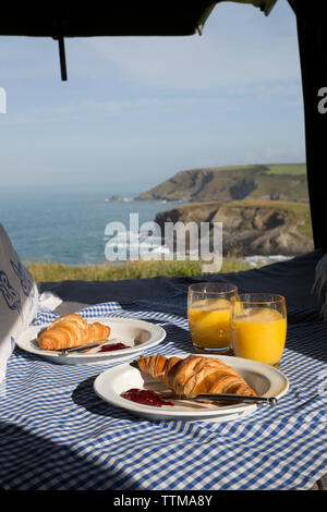 Petit-déjeuner à bed par fenêtre contre la mer en autocaravane Banque D'Images