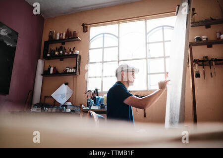 Milieu de l'artiste cubain adultes avec pinceau peinture sur toile dans son atelier Banque D'Images