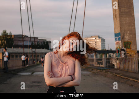 Jeune femme marche sur bridge en ville