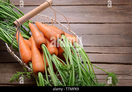 Carottes fraîches dans le panier sur la table en bois Banque D'Images