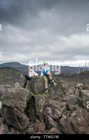 USA, Oregon, Oregon Cascades, deux garçons jouer autour de la roche au Dee Wright Observatoire dans le milieu d'une ancienne coulée en haut de l'McKe Banque D'Images