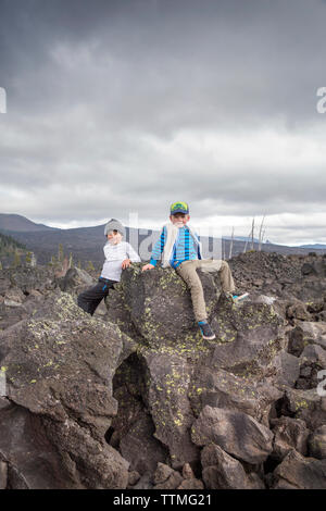 USA, Oregon, Oregon Cascades, deux garçons jouer autour de la roche au Dee Wright Observatoire dans le milieu d'une ancienne coulée en haut de l'McKe Banque D'Images