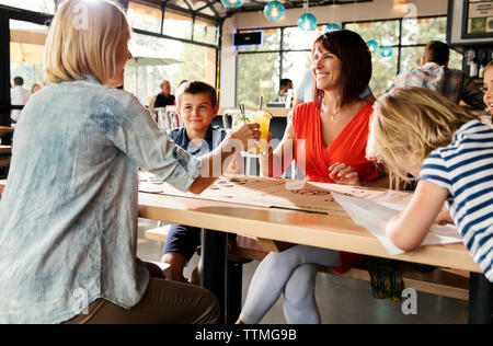 USA (Oregon, Bend, Pacific Pizza et Brew, les femmes avec les enfants boissons cheers Banque D'Images