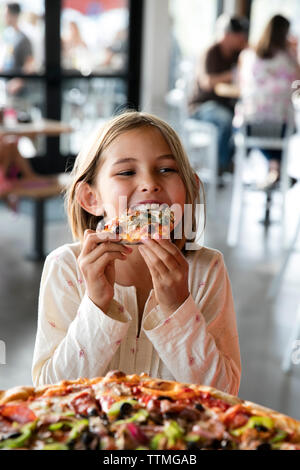 USA (Oregon, Bend, Pacific Pizza et Brew, girl eating pizza Banque D'Images
