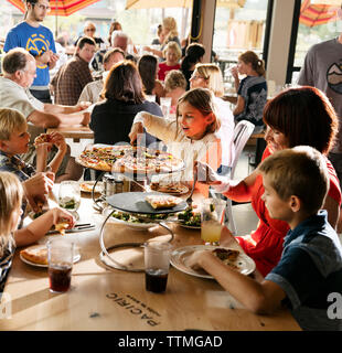 USA (Oregon, Bend, Pacific Pizza et Brew, enfants à manger une pizza Banque D'Images