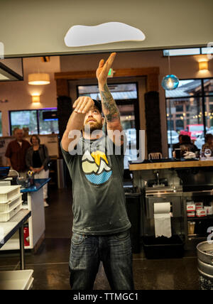USA (Oregon, Bend, Pacific Pizza et Brew, chef de pizza tossing pâte Banque D'Images